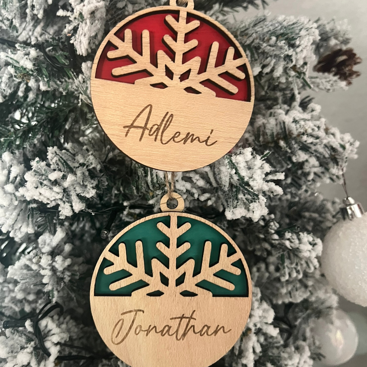 Bolas de Navidad de madera con copo de nieve en rojo y verde y nombres grabados, Lunera
